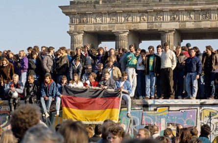 People from East and West Berlin climbing on the Wall at the Brandenburg Gate, Berlin, Germany in 1989.