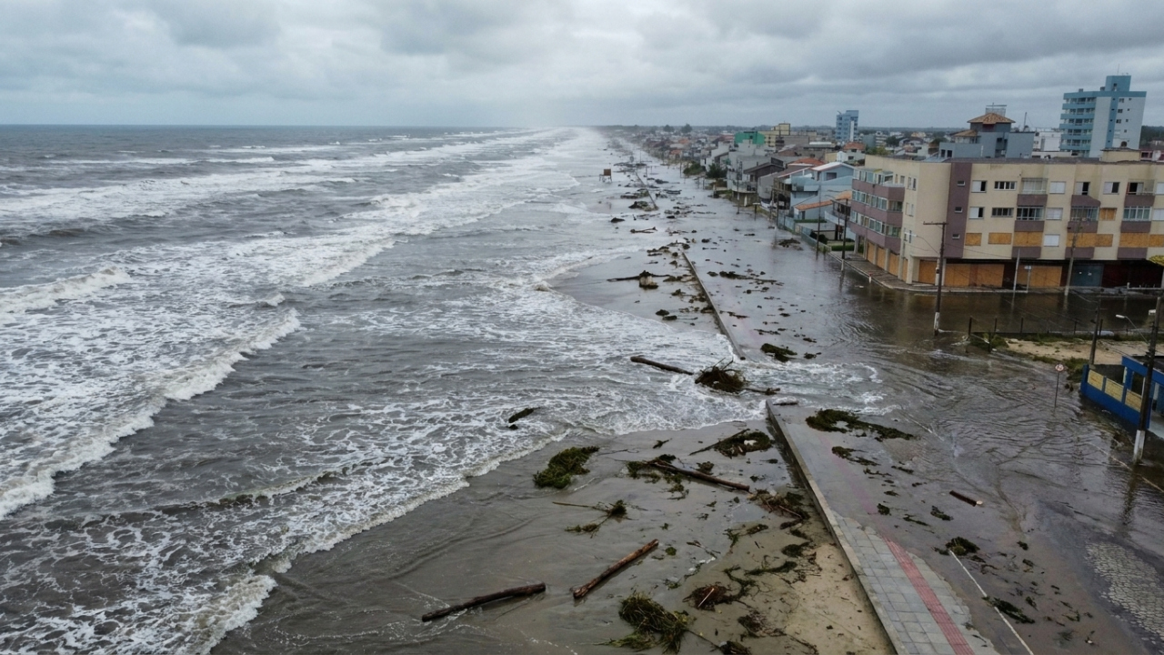 A cidade do Sul onde uma ressaca faz o oceano atravessar a praia, invadir a avenida, alcançar casas e mobilizar máquinas contra troncos e vegetação