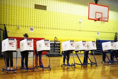 Voters cast ballots at rolling booths in a gymnasium during early voting