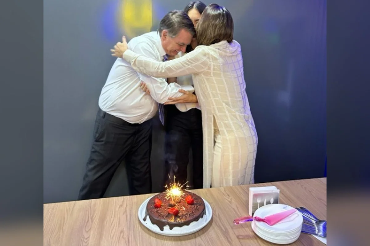Aniversário de 15 anos de Laurinha. A adolescente está abraçada com Jair e Michelle Bolsonaro