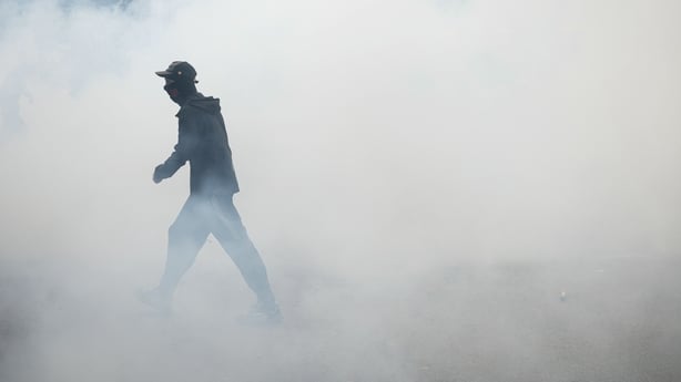 A protester walks in tear gas as students carry out a blocking protest at the Strasbourg University