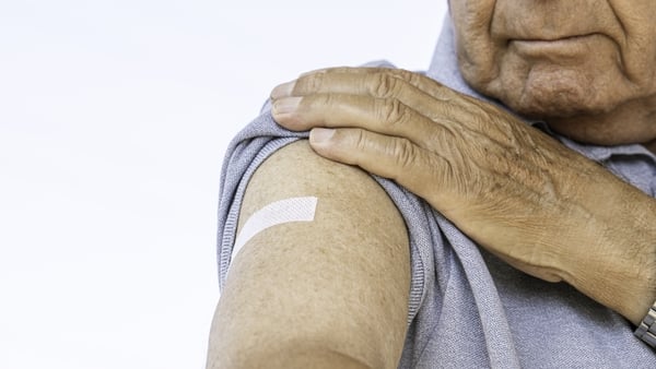 Older man looking at his arm after vaccination.